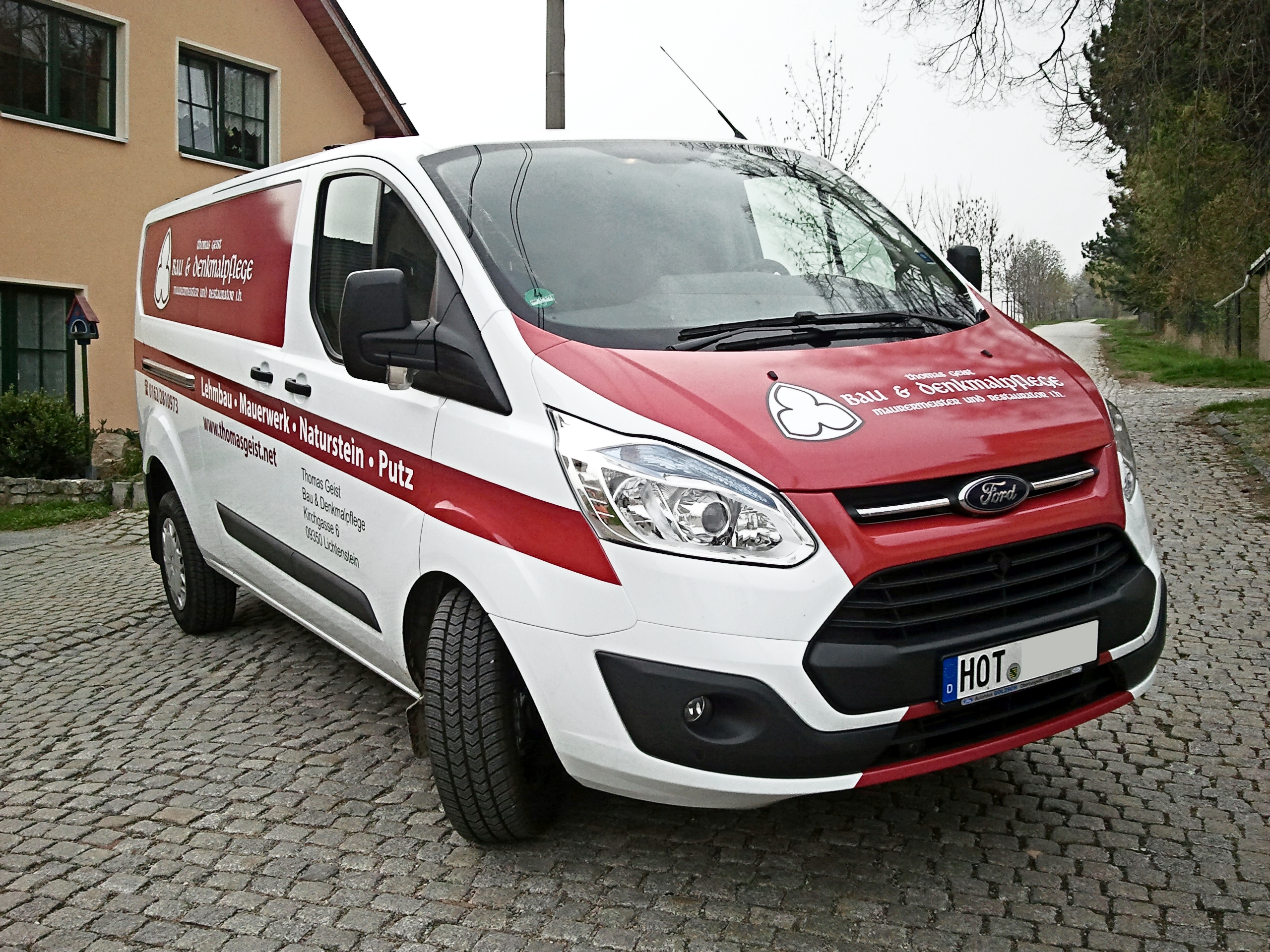 teilweise retroreflektierende Beschriftung an schwarzem Mercedes Vito Transporter